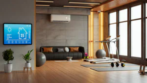 Smart thermostat displaying 25°C mounted on wall in modern home gym with split AC unit, yoga mats, dumbbells, and treadmill