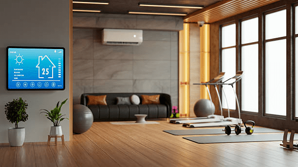 Smart thermostat displaying 25°C mounted on wall in modern home gym with split AC unit, yoga mats, dumbbells, and treadmill