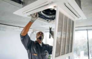 Technician repairing a ceiling cassette AC unit