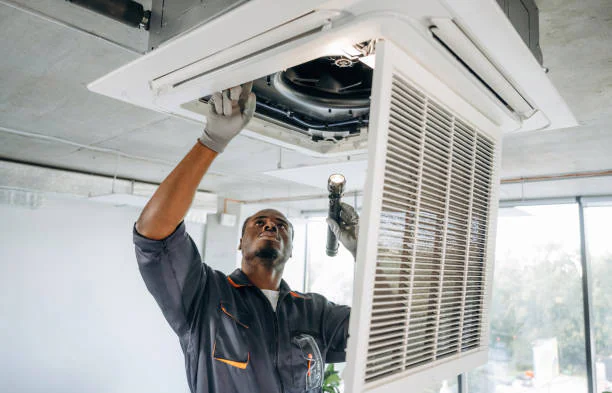 Technician repairing a ceiling cassette AC unit